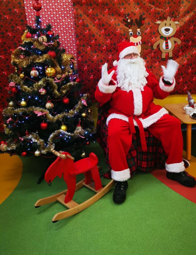 Choinka i Mikołaj siedzący na krześle